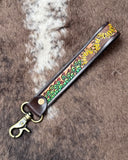 Leather keychain with sunflower design on a textured surface