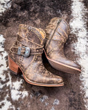Pair of brown leather boots with decorative elements on a textured surface