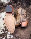 Brown leather boot with wooden sole on a textured surface