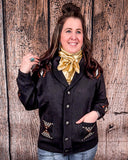A woman wearing the Stand by Me Knit Sweater buttoned up with one hand in her pocket and one hand holding a piece of her hair. She is also wearing a gold wild rag and medium wash jeans.