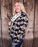 A girl wearing the Aztec City Soft Shell Jacket, standing side ways while looking into the distance. She is standing in front of a wood back drop.