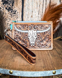 The Pride of Prickly Pears Card Holder in Dark Brown displayed on a wooden table with wheat in the back ground, sitting in front of a wood back drop.
