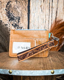 The back of the Pride of Prickly Pears Card Holder in Dark Brown, showing the card slots and wristlet. Wheat in the back ground.