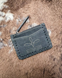 The Outlander Edge Credit Card Holder in Ash Grey displayed on cowhide.