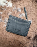 The Outlander Edge Credit Card Holder in Ash Grey, laid on it's front to show the back of it on cowhide.