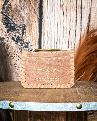 The  Outlander Edge Credit Card Holder in Beige displayed on a wooden table with wheat behind it, sitting in front of a wood backdrop.
