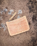 The  Outlander Edge Credit Card Holder in Beige displayed on cowhide.
