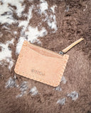 The  Outlander Edge Credit Card Holder in Beige, flipped on it's front to show the back of the holder. It is being displayed on cowhide.