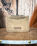 Back view of the Outlander Edge Credit Card Holder in Brown, displayed on a wooden table with wheat behind it. It is sitting in front of a wood back drop.