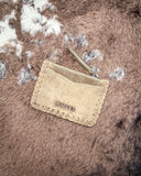 The Outlander Edge Credit Card Holder in Brown, flipped over to show the back of the holder. It is being displayed on cowhide.