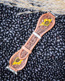 The Lone Star Hand Tooled Leather Watch Band in Antique Tan displayed on beans and wheat.