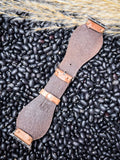 The back of the Lone Star Hand Tooled Leather Watch Band in Antique Tan displayed on beans and wheat.