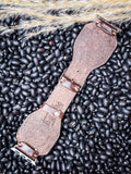 The back of the Lone Star Hand Tooled Leather Watch Band in Antique Mahogany displayed on beans and wheat.