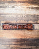 The Lone Star Hand Tooled Leather Watch Band in Antique Mahogany sitting on a ruler to show size, displayed on a wooden table.