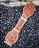 The Lone Star Hand Tooled Leather Watch Band in Antique Saddle Brown displayed on beans and wheat.