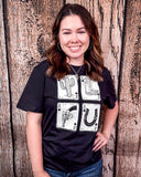 A girl modeling the Four Aces Graphic Tee in a wood back ground.