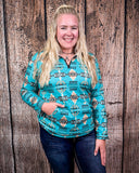 A model wearing the Laramie Kreek Fitted Pullover with her hand in her pocket, the other resting on her leg in a wood back ground.