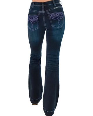 Rustic women's dark blue flare jeans with purple embroidered details on the back pockets, shown from the back on a model against a white background.