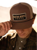 Model wearing Cactus ropes hat looking down holding the bill of the hat