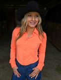 A cow girl wearing the Spur and Spark Pullover Button Up in a barn.