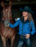 Model posing in the Ranch Ready Pullover Button Up next to a horse,