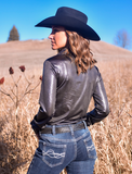 Back view of the model wearing the Obsidian Rush Pullover Button Up in a field.