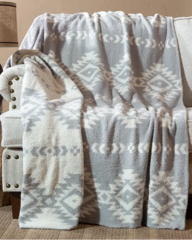 Gray and white Aztec patterned blanket draped over a chair