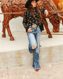 Person in a western outfit with a bull sculpture in the background