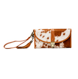 Cow print clutch bag with brown strap on a white background