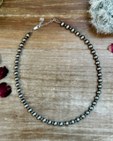 Necklace with silver beads on a wooden surface