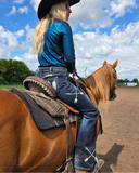 Person riding a horse in an outdoor setting with a blue sky and clouds.