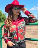 Person wearing a red cowboy hat, floral shirt, and sunglasses outdoors.