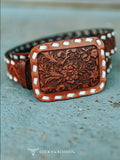Flat lay of the Brown Tooled Genuine Leather Ivory Buckstitch Belt on cement.