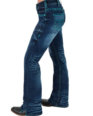 A side profile view of a person wearing dark blue flared denim jeans with bright turquoise contrast stitching and decorative stitching on the back pocket, paired with dark brown boots against a white background.