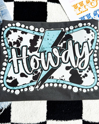 Black t-shirt with 'Howdy' design on a checkered surface