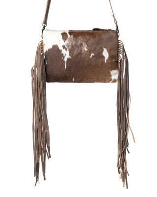 Brown and white cowhide handbag with fringes on a white background