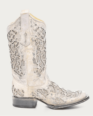 A single western cowboy boot in distressed off-white leather with intricate silver and gray embroidered detailing, shown from a side profile against a light gray background.