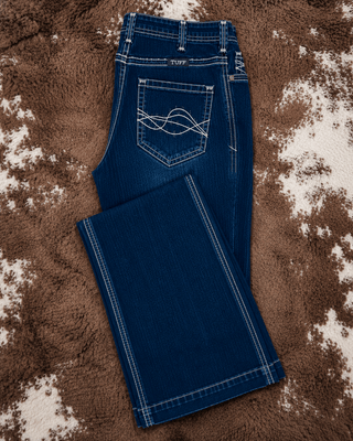 A pair of dark blue denim jeans with white contrast stitching and a wave-like embroidery on the back pocket, laid flat on a brown and white cowhide rug.