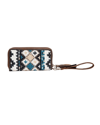 A zip-around wallet with a geometric Southwestern-style woven pattern in black, white, beige, and teal, featuring brown leather trim and a matching wristlet strap with a tassel.