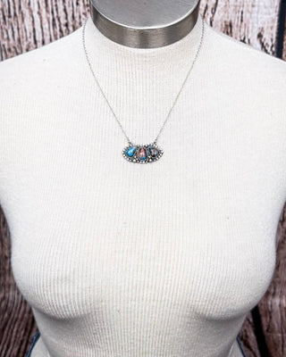 Three-stone southwestern necklace with turquoise and jasper on silver chain displayed on mannequin