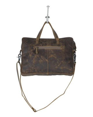 Brown leather bag with a strap on a white background