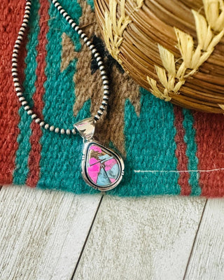 Necklace with a colorful pendant on a textured surface