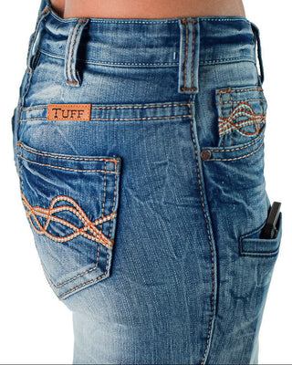 Close-up rear view of blue denim jeans worn by a model, showing the back pockets with decorative orange stitching and a small brown leather patch that reads TUFF.