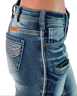 Close-up of the back waistband and pockets of blue denim jeans worn by a model, showing a small orange TUFF brand patch on the back pocket.