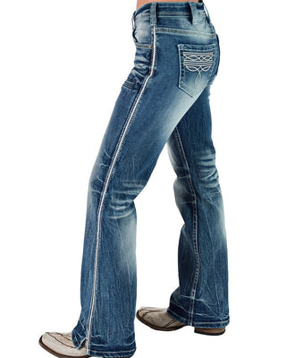 A side profile view of a person wearing blue western-style jeans with a flare leg, featuring contrast stitching and decorative embroidery on the back pocket, paired with brown boots against a white background.