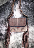 Front view of the Sandy Rosewood Hand-Tooled Bag displayed on cow hide.
