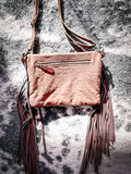 Back view of the Sandy Rosewood Hand-Tooled Bag displayed on cow hide.
