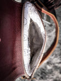 Inside of the Sandy Rosewood Hand-Tooled Bag displayed on cow hide.