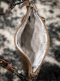 Inside of the Azure Aesthetic Leather & Hairon Bag displayed on cow hide.