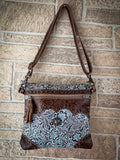 Front view of the Azure Aesthetic Leather & Hairon Bag hanging on a brick wall.
